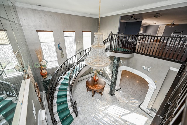 interior space featuring a ceiling fan, arched walkways, and crown molding