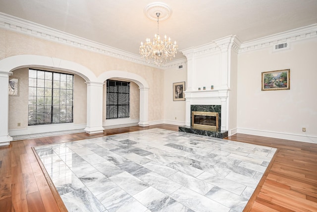 unfurnished living room featuring wood-type flooring, a fireplace, visible vents, and crown molding