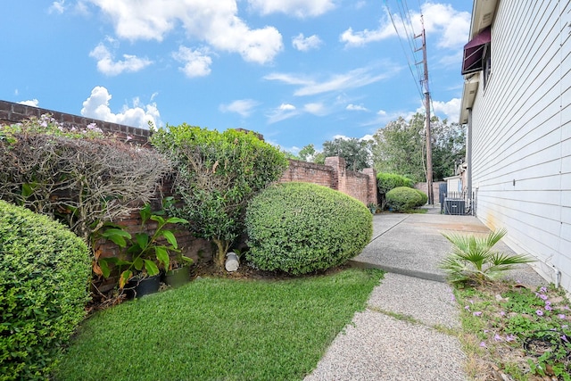 view of yard featuring central AC unit, fence, and a gate