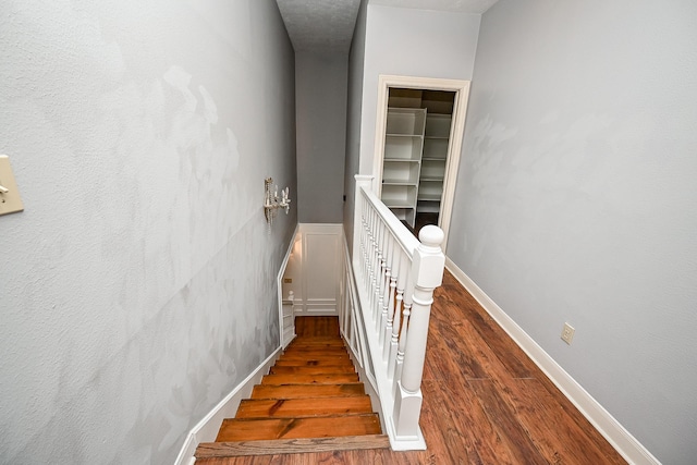 stairway featuring baseboards and wood finished floors