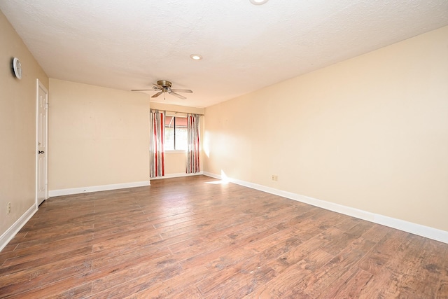 spare room featuring a ceiling fan, a textured ceiling, baseboards, and wood finished floors