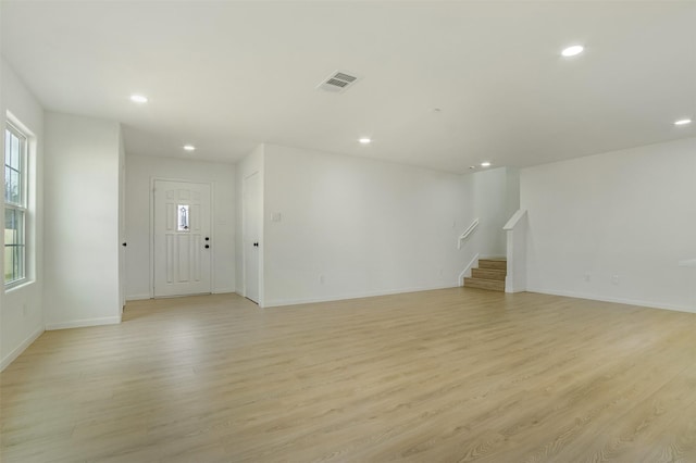 unfurnished living room with recessed lighting, visible vents, light wood-style floors, and stairs