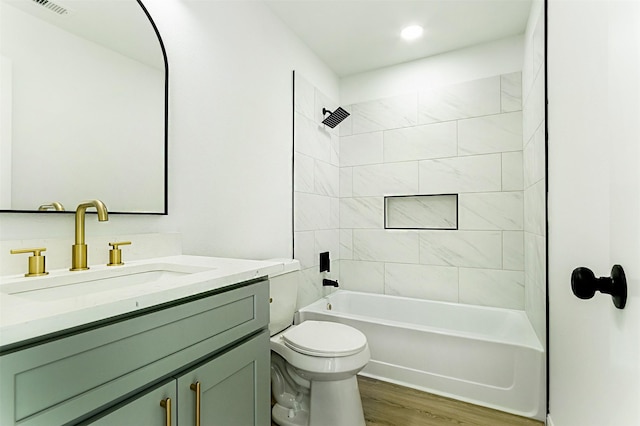 bathroom with toilet, shower / washtub combination, wood finished floors, and vanity