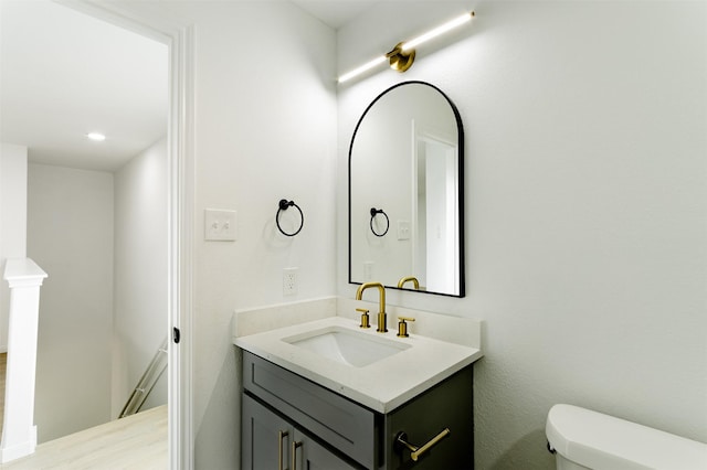 bathroom with recessed lighting, toilet, and vanity