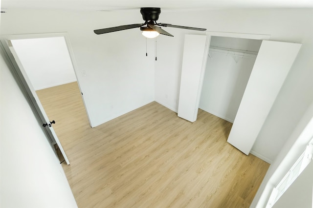 unfurnished bedroom featuring a closet, light wood-style floors, and ceiling fan