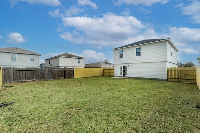 rear view of house with a patio, a lawn, and a fenced backyard