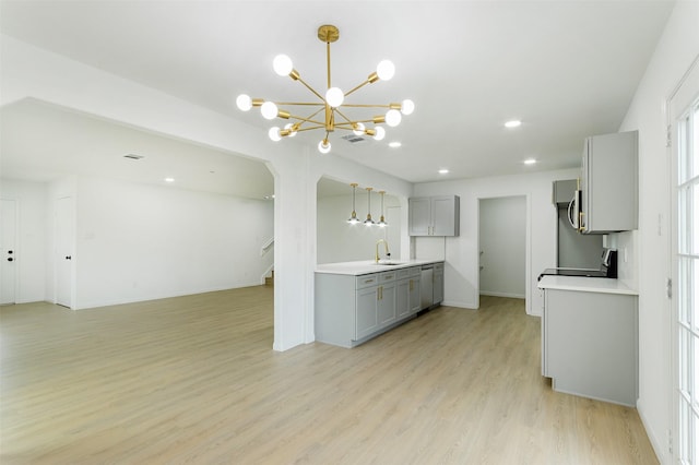 kitchen with visible vents, a sink, gray cabinetry, light countertops, and light wood-style floors