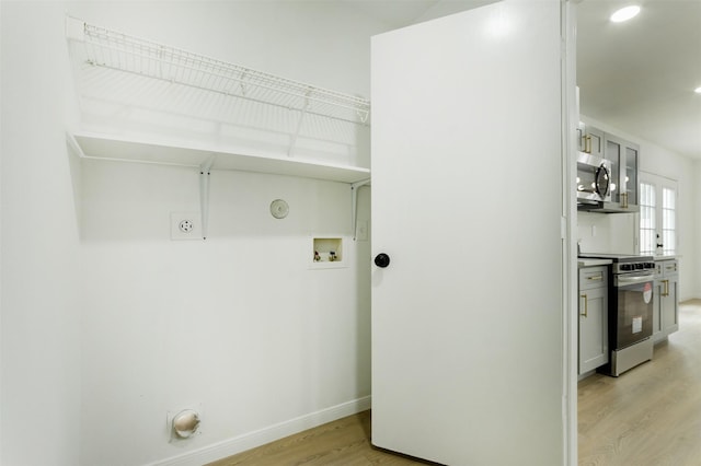 washroom featuring baseboards, washer hookup, light wood-style floors, hookup for a gas dryer, and electric dryer hookup