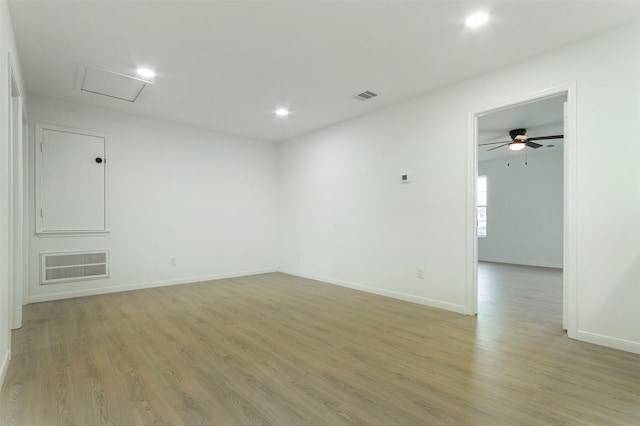 spare room featuring visible vents, attic access, and light wood finished floors