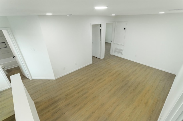 spare room featuring visible vents, light wood-type flooring, and baseboards