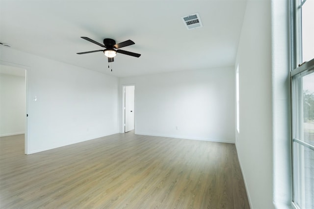 unfurnished room featuring visible vents, light wood-style flooring, baseboards, and ceiling fan