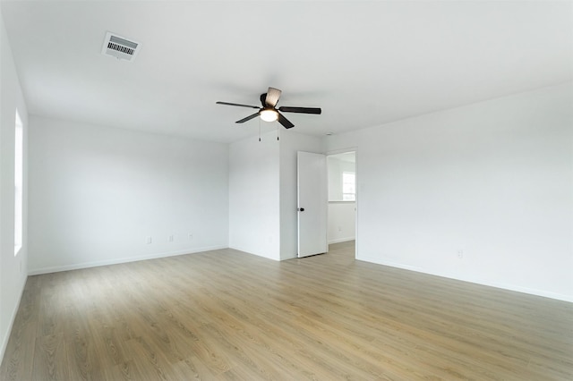 unfurnished room with visible vents, baseboards, light wood-type flooring, and ceiling fan