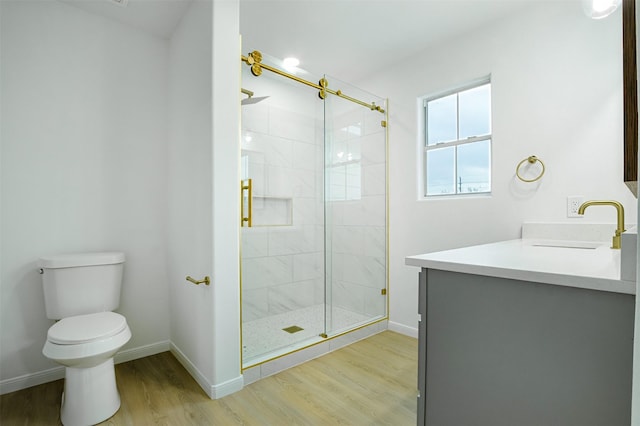 bathroom featuring a stall shower, toilet, and wood finished floors