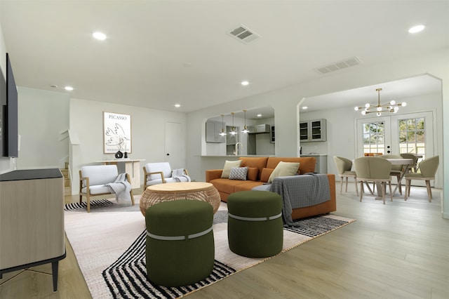 living area featuring a notable chandelier, visible vents, recessed lighting, and light wood-type flooring