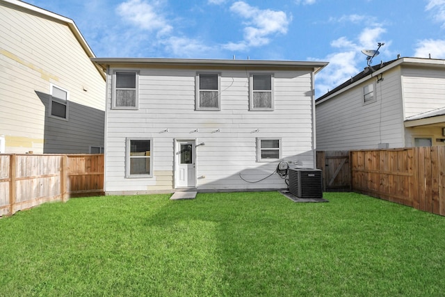 back of property with central air condition unit, a fenced backyard, and a yard