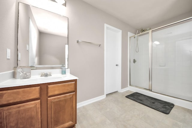 bathroom with a stall shower, baseboards, and vanity