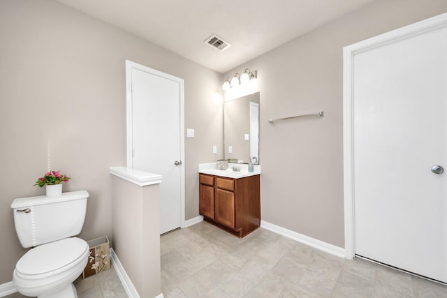 bathroom with visible vents, toilet, vanity, and baseboards