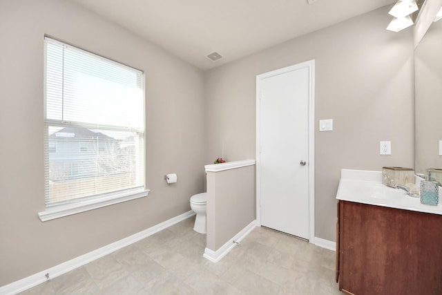 bathroom with visible vents, toilet, vanity, and baseboards