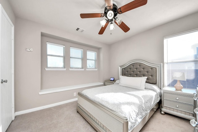 bedroom featuring baseboards, ceiling fan, visible vents, and light colored carpet