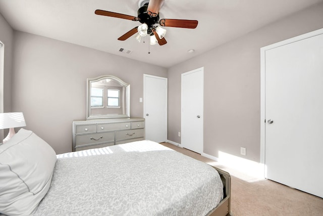 carpeted bedroom featuring visible vents and a ceiling fan