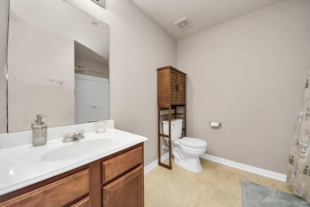 bathroom featuring toilet, vanity, visible vents, and baseboards