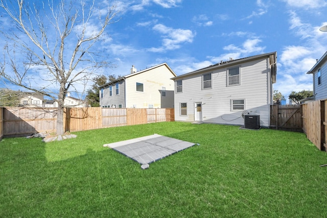 rear view of house featuring a yard, central AC unit, a patio area, and a fenced backyard