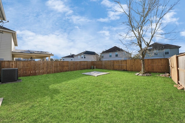 view of yard with central AC unit and a fenced backyard