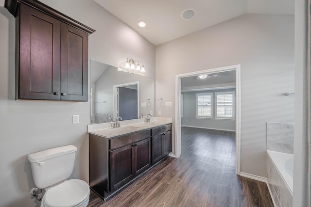 full bath featuring vaulted ceiling, a sink, toilet, and wood finished floors