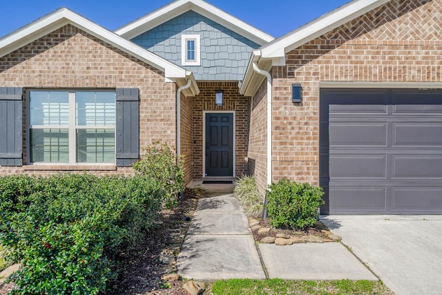 entrance to property featuring a garage and brick siding