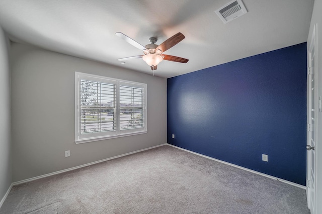 empty room with ceiling fan, carpet, visible vents, and baseboards