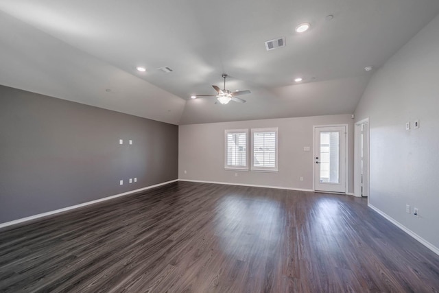 spare room featuring lofted ceiling, ceiling fan, dark wood-style flooring, visible vents, and baseboards