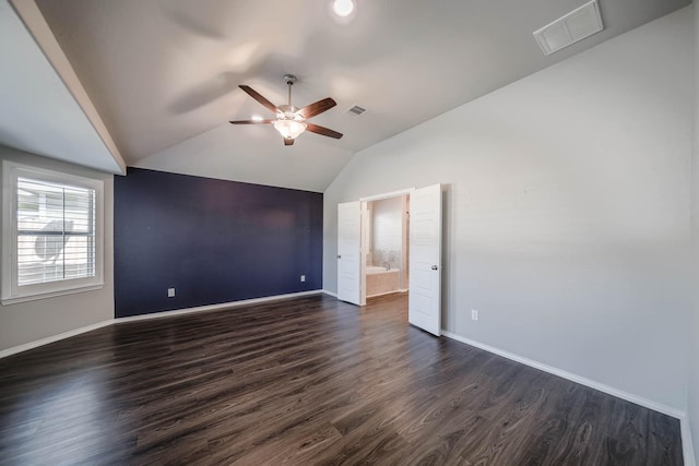 spare room featuring dark wood finished floors, lofted ceiling, visible vents, ceiling fan, and baseboards