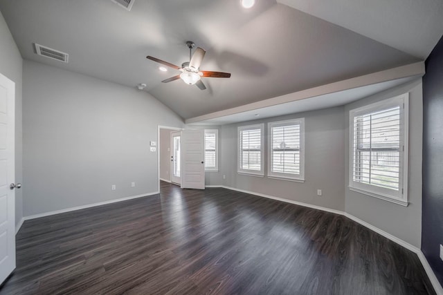 empty room with baseboards, visible vents, vaulted ceiling, and dark wood-type flooring