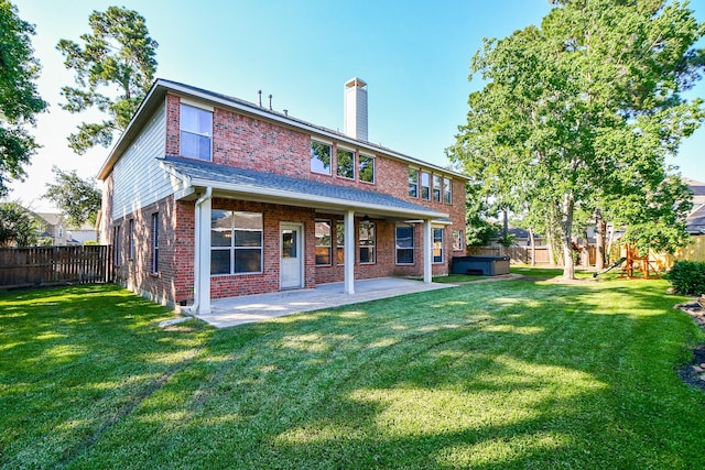 rear view of property featuring a hot tub, a fenced backyard, a chimney, a patio area, and brick siding