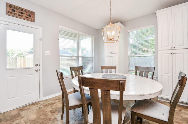 dining space with a chandelier, plenty of natural light, and baseboards