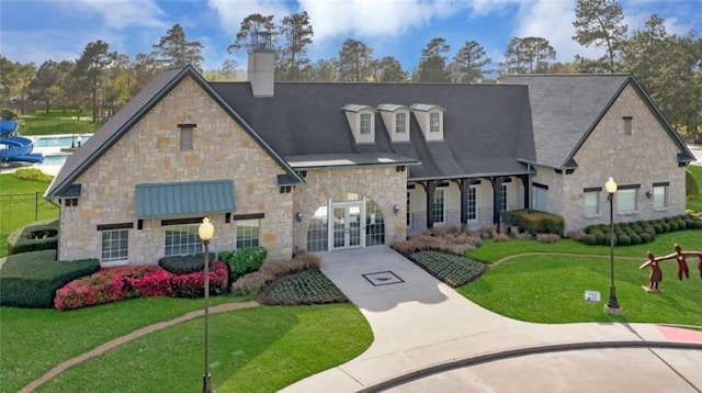 view of front of house featuring a front yard, french doors, and a chimney