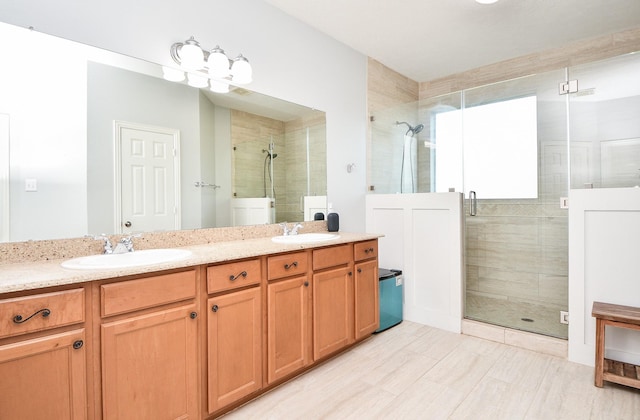 full bath with double vanity, a stall shower, and a sink