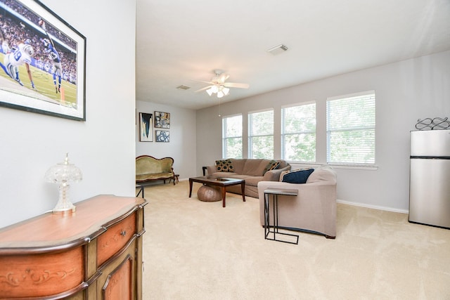 living room featuring visible vents, plenty of natural light, light carpet, and ceiling fan