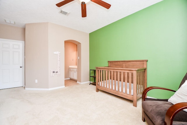 bedroom with arched walkways, carpet flooring, a ceiling fan, visible vents, and baseboards