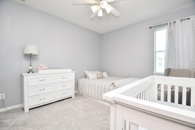 bedroom with light carpet, ceiling fan, and baseboards