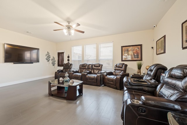 living area with wood finished floors, a ceiling fan, and baseboards