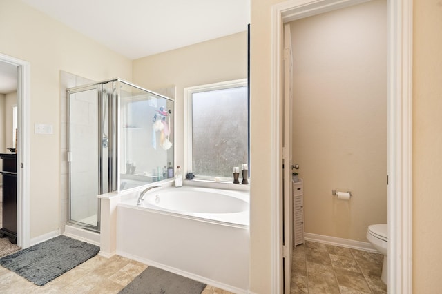 bathroom with baseboards, a garden tub, a shower stall, and toilet