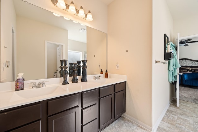 bathroom with double vanity, baseboards, and a sink