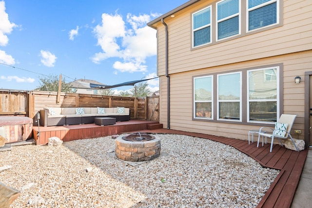 exterior space with fence, a deck, and an outdoor living space with a fire pit