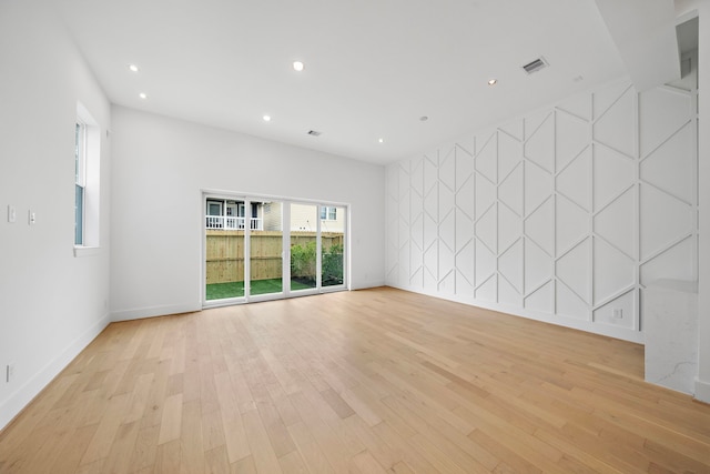 unfurnished room featuring baseboards, light wood-style flooring, visible vents, and recessed lighting