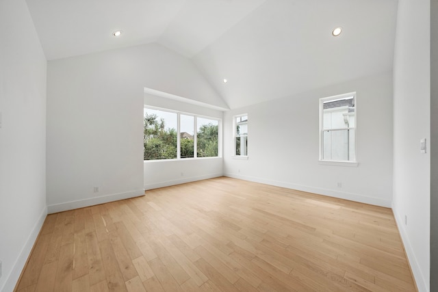 spare room with high vaulted ceiling, recessed lighting, light wood-type flooring, and baseboards