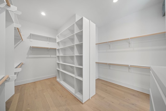 walk in closet with light wood-style floors