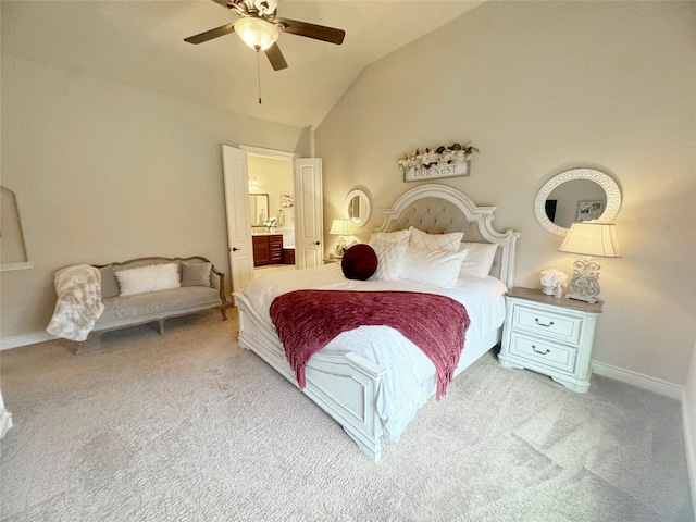 carpeted bedroom with a ceiling fan, lofted ceiling, baseboards, and ensuite bath