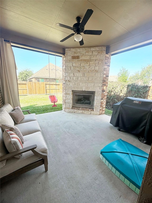 view of patio / terrace featuring a fenced backyard, ceiling fan, grilling area, and an outdoor living space with a fireplace