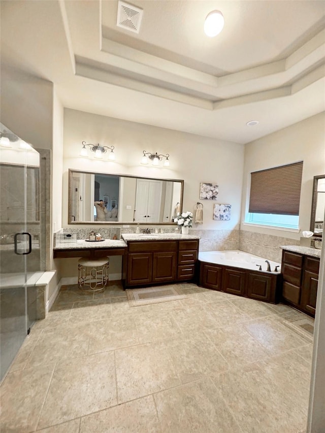 bathroom featuring a stall shower, a raised ceiling, visible vents, and vanity